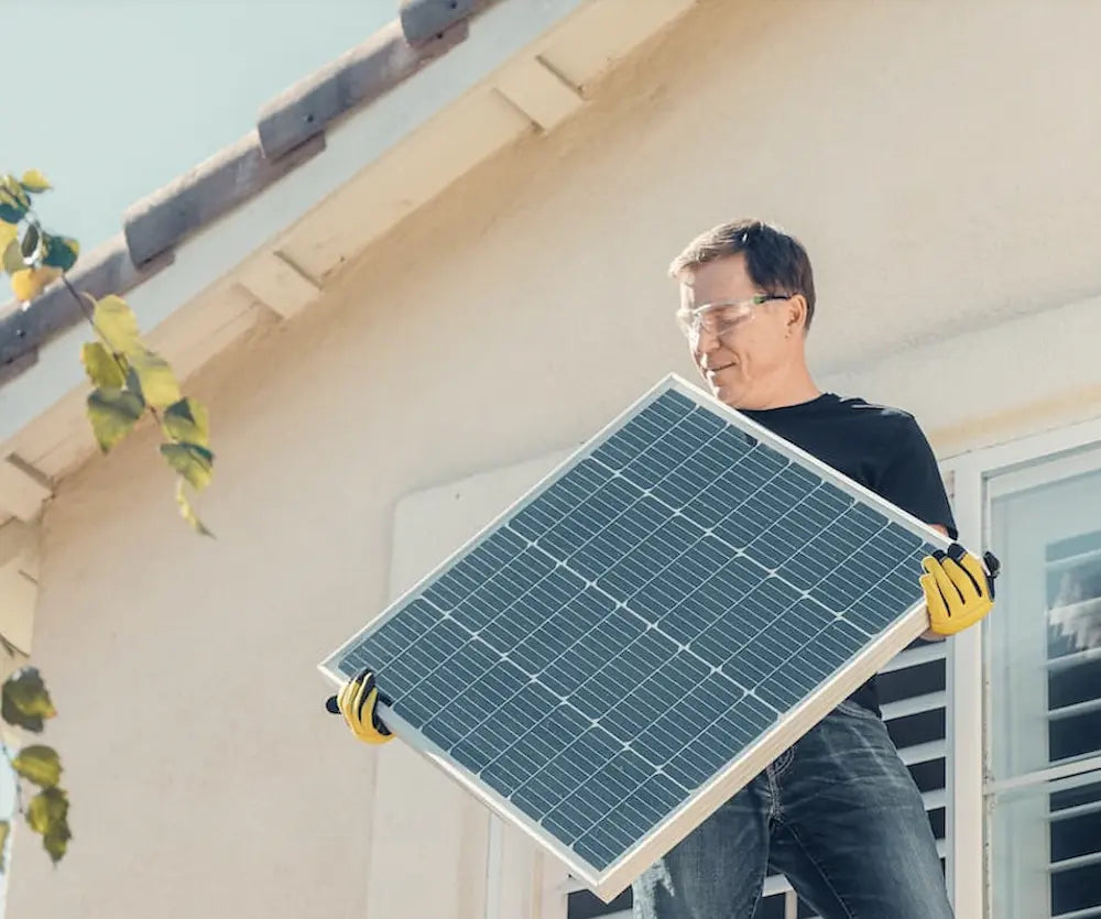 Un homme qui emmène un panneau solaire photovoltaïque au recyclage